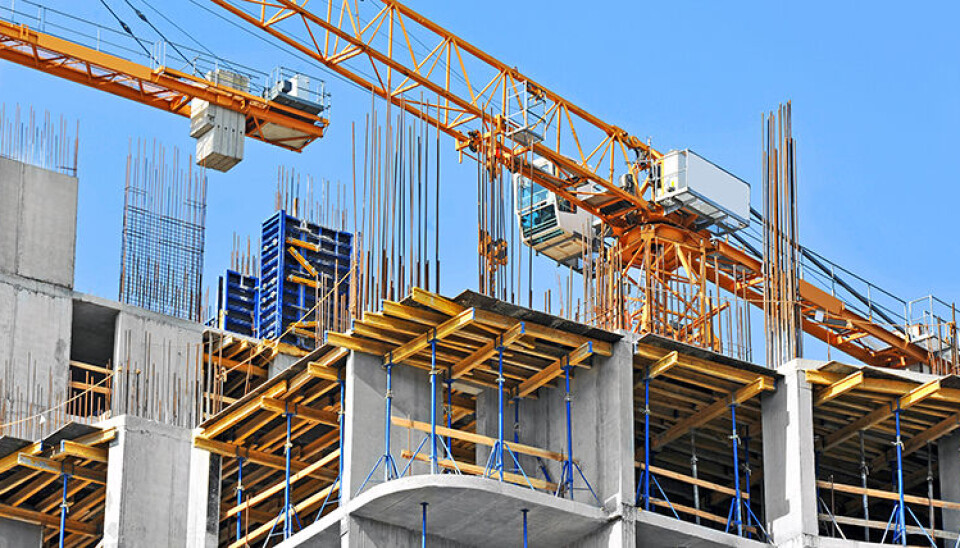 Crane and building construction site against blue sky