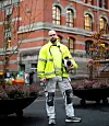 Håndverker i refleksjakke står foran historisk murbygg under rehabilitering.
