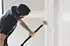 Person sliper eller sparkler innvendig vegg med forlengerskaft.